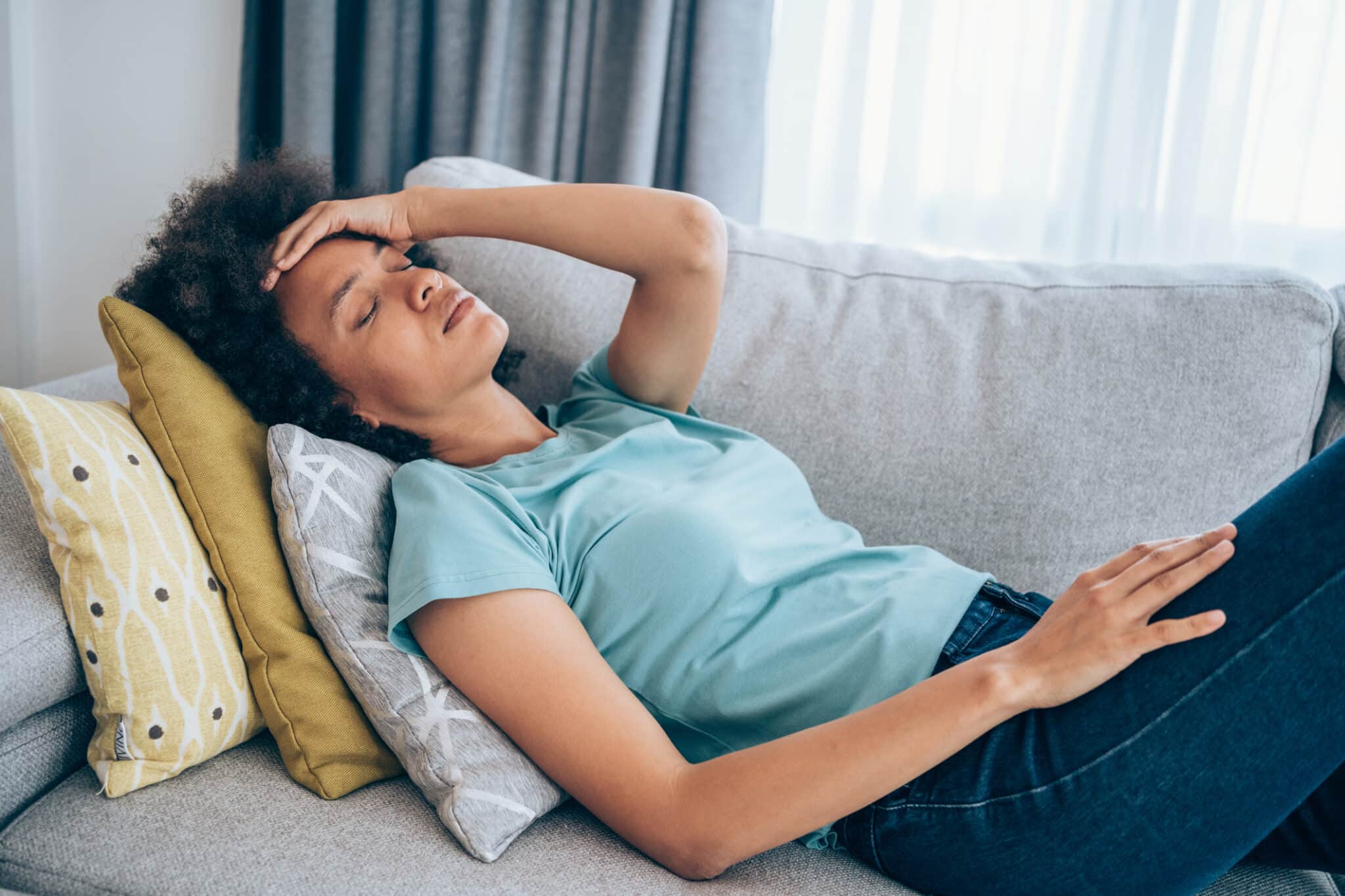 Woman lying on couch with body aches
