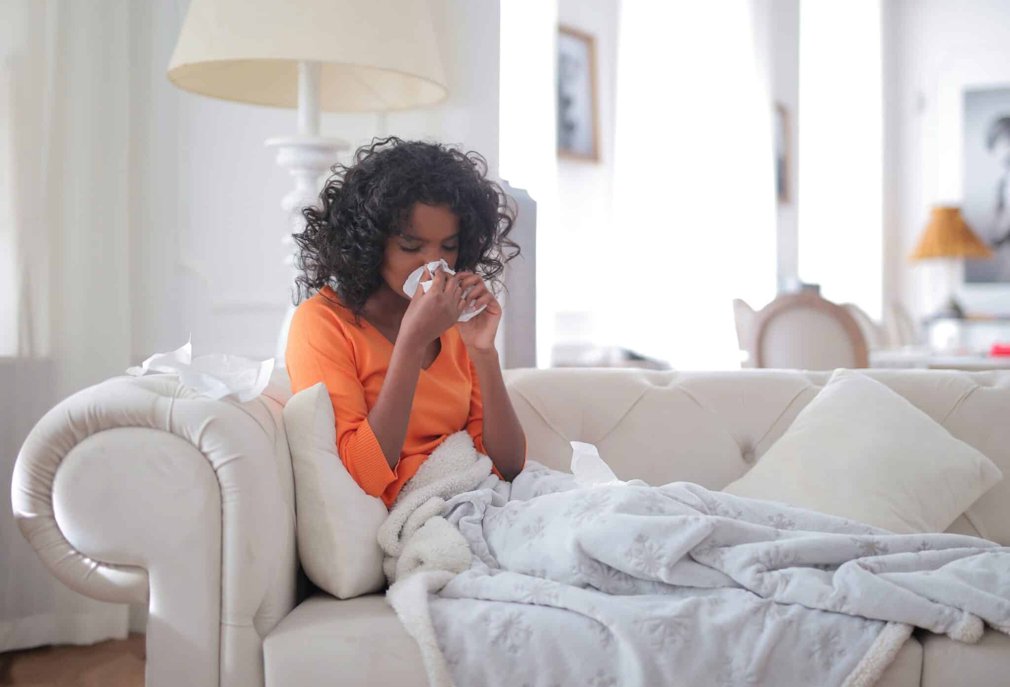 Woman sick with a sinus infection at home on her couch.