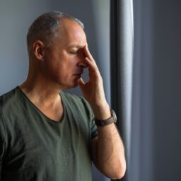 Man with sinusitis touching his face