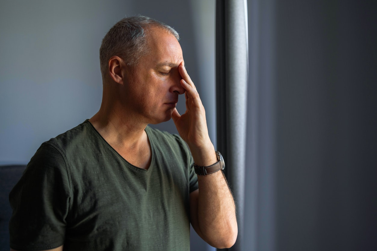 Man with sinusitis touching his face
