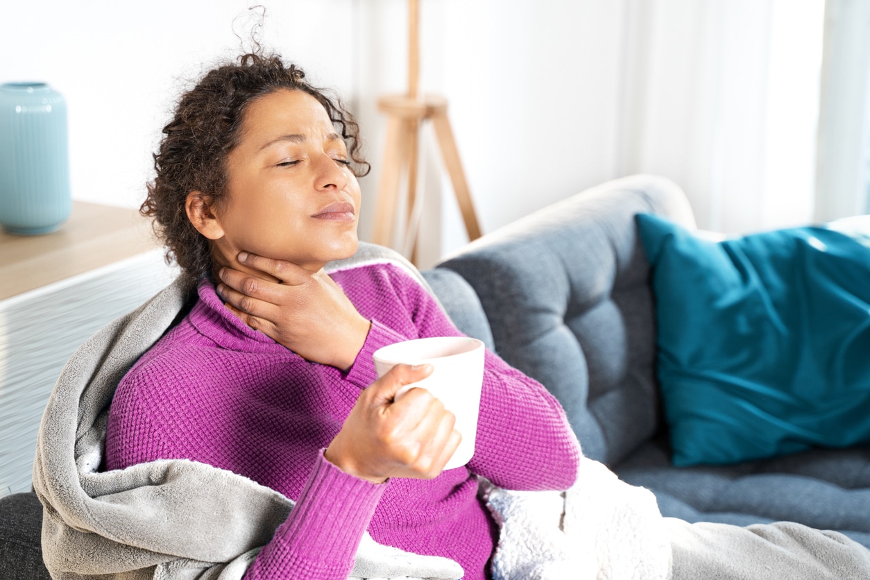 Woman holding her sore throat