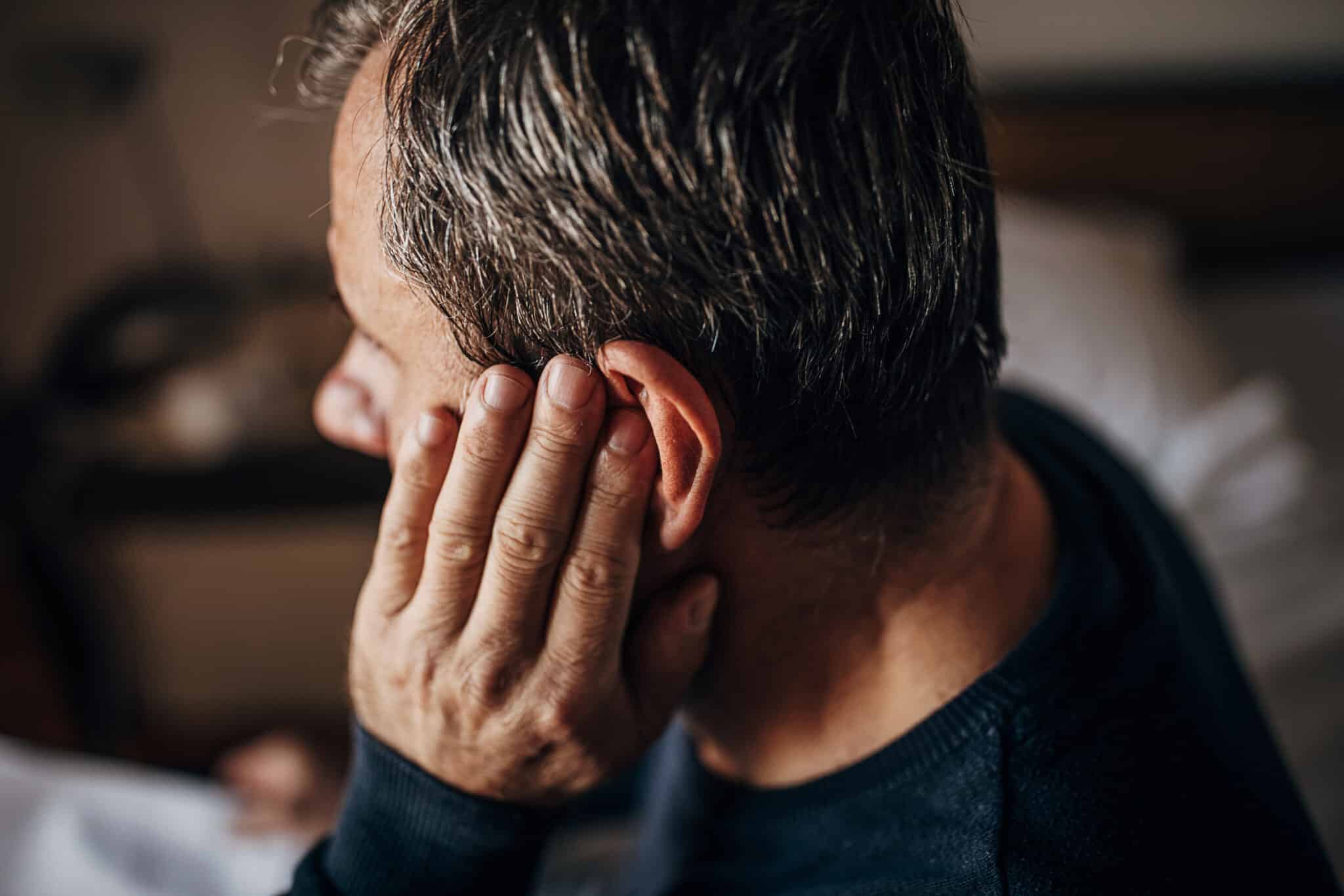 Older man with ear pain from allergies.