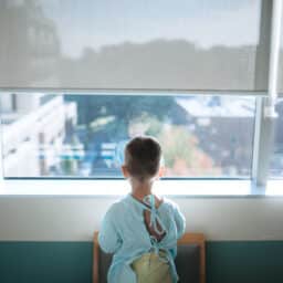 Young boy looks out window prior to surgery
