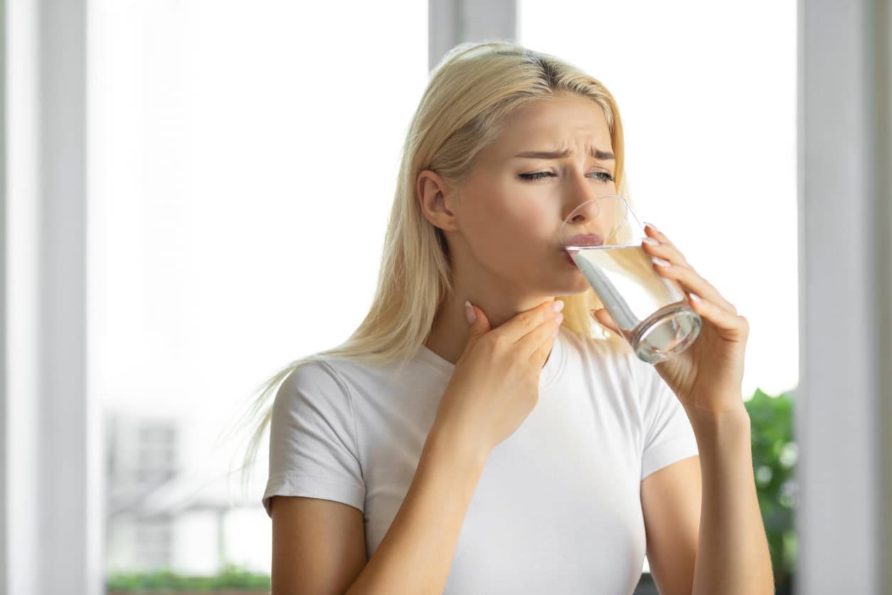 Woman struggling to swallow water.