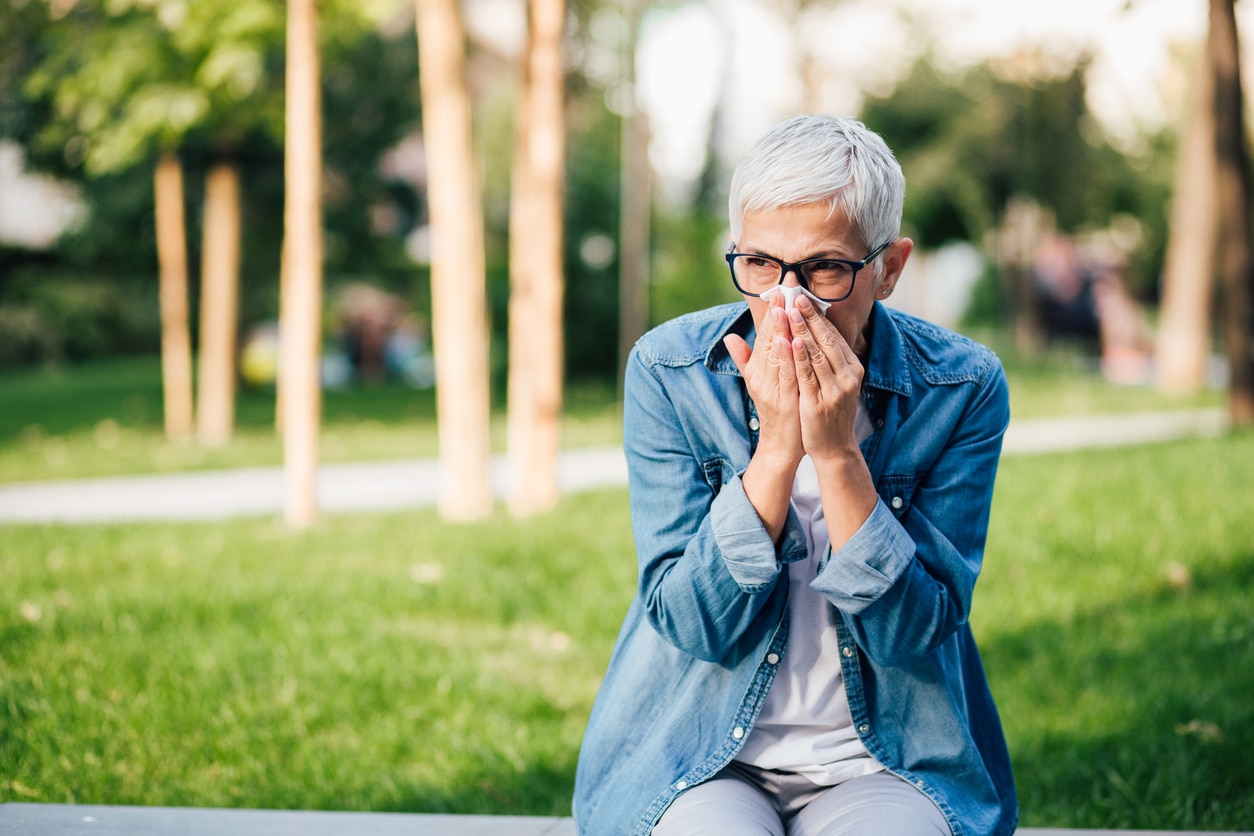 Woman sneezing in the park