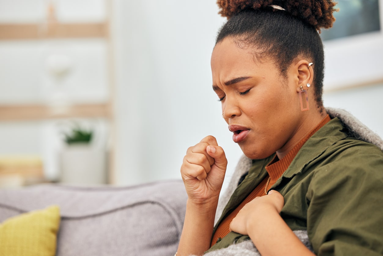 Woman coughing and holding her chest