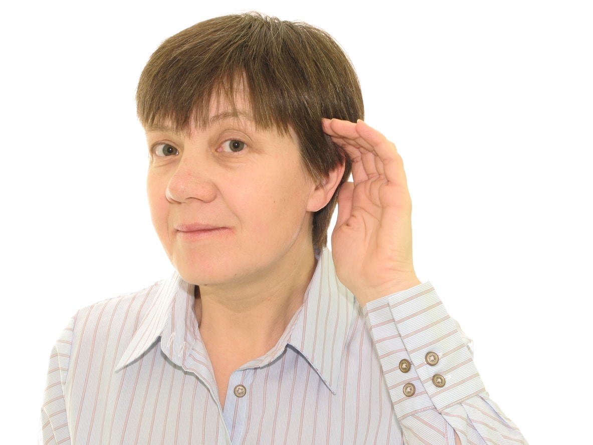 Woman with her hand to her ear straining to understand