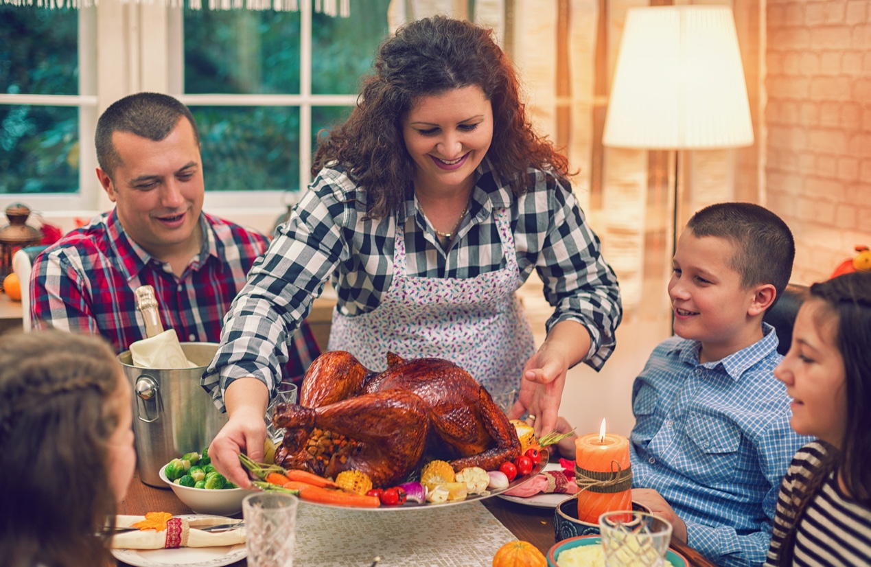 Mom bringing a roast turkey to the dinner table