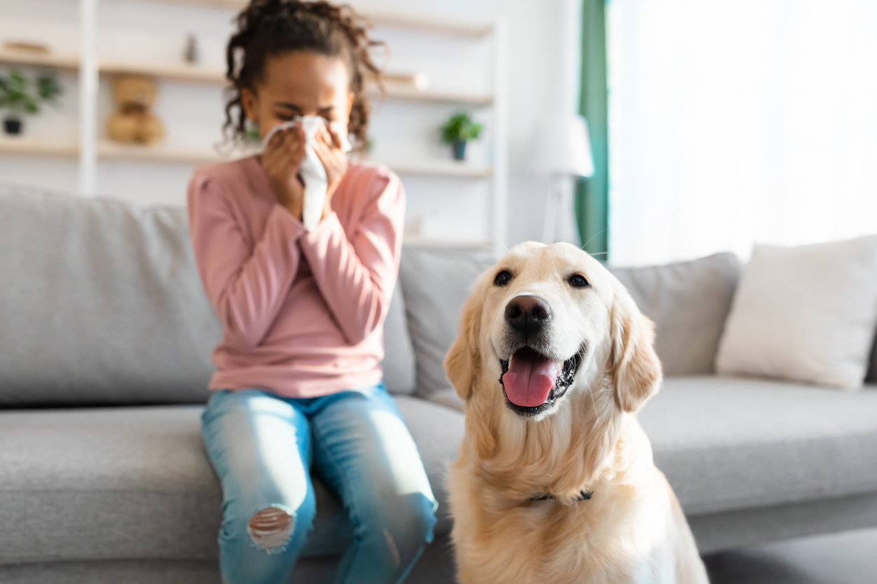 Girl suffering from a sinus infection next to a dog