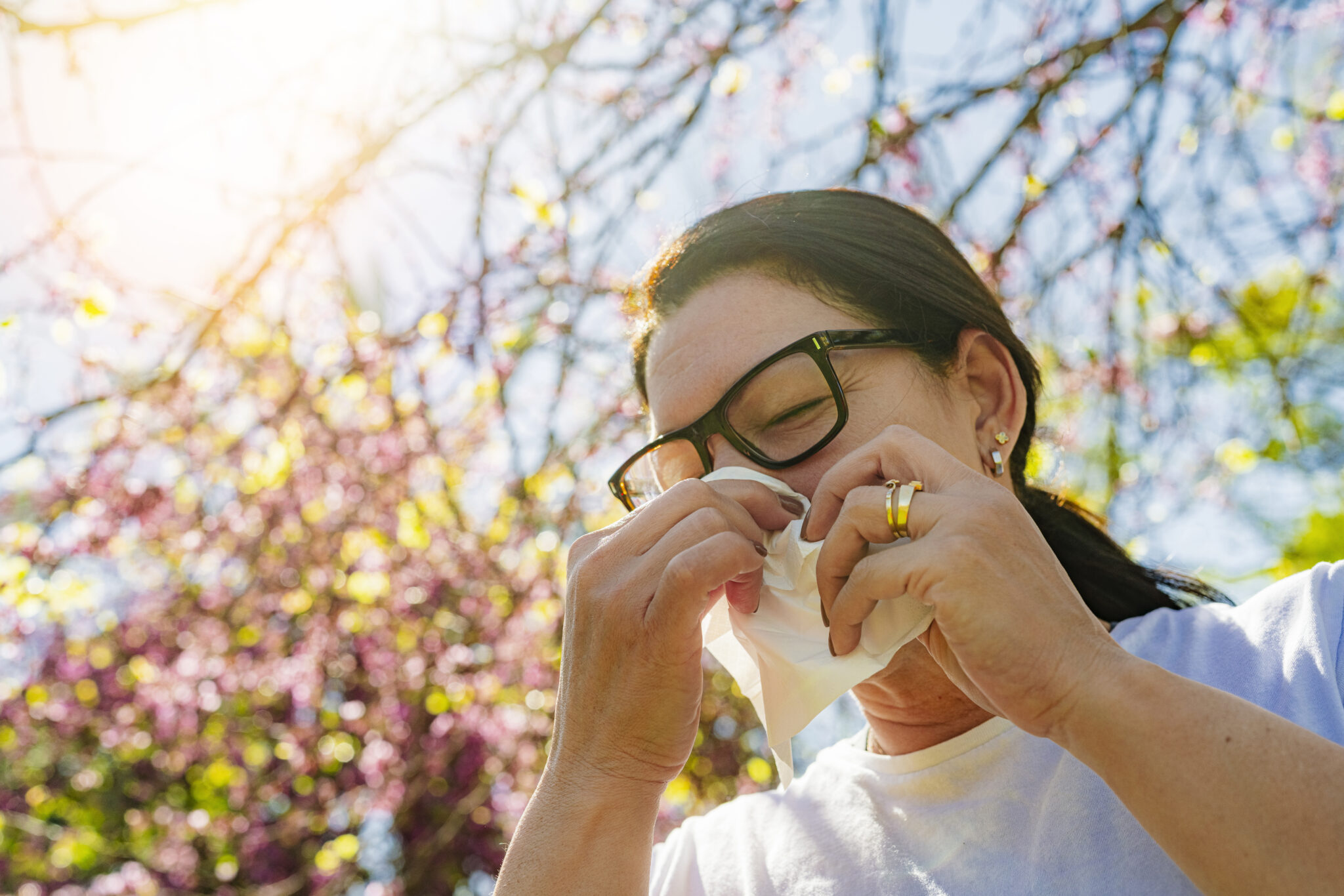 Woman blowing her nose during allergy season.