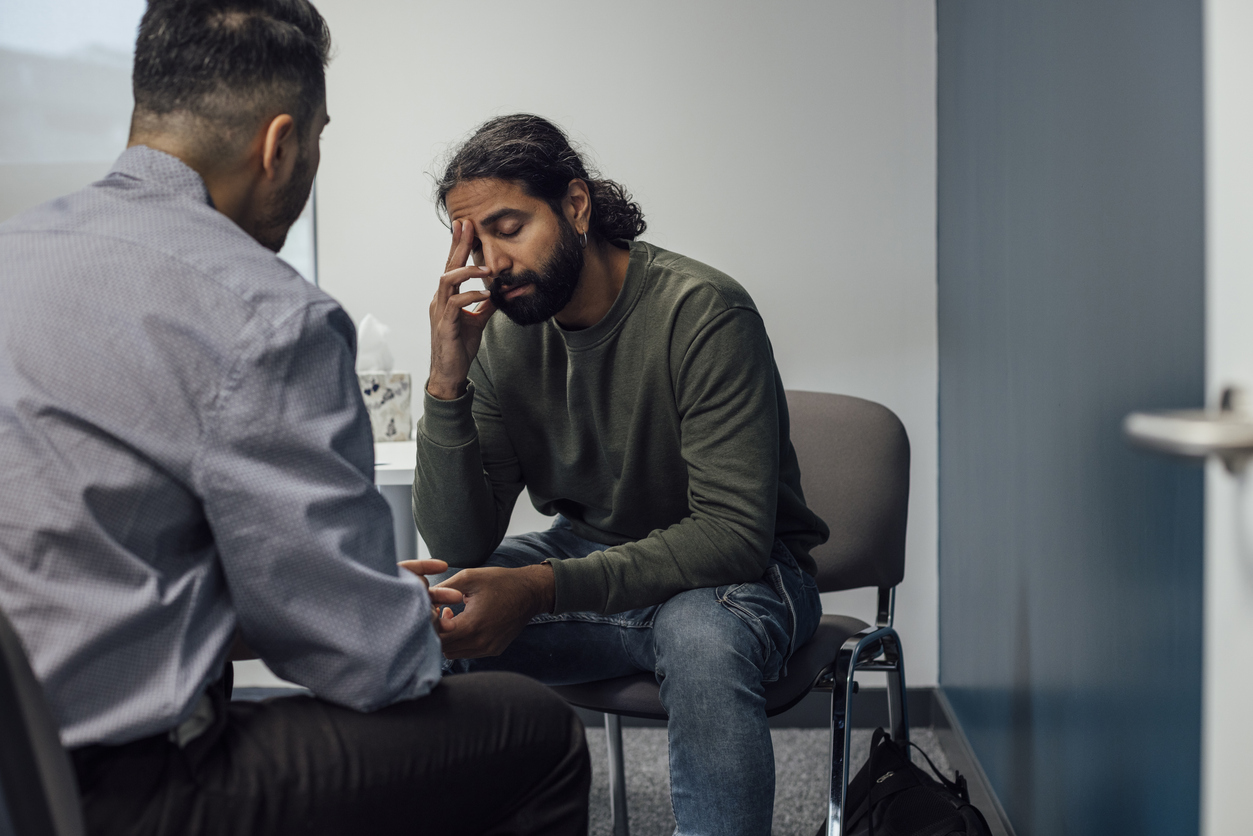 Tired man dealing with listening fatigue struggles to pay attention