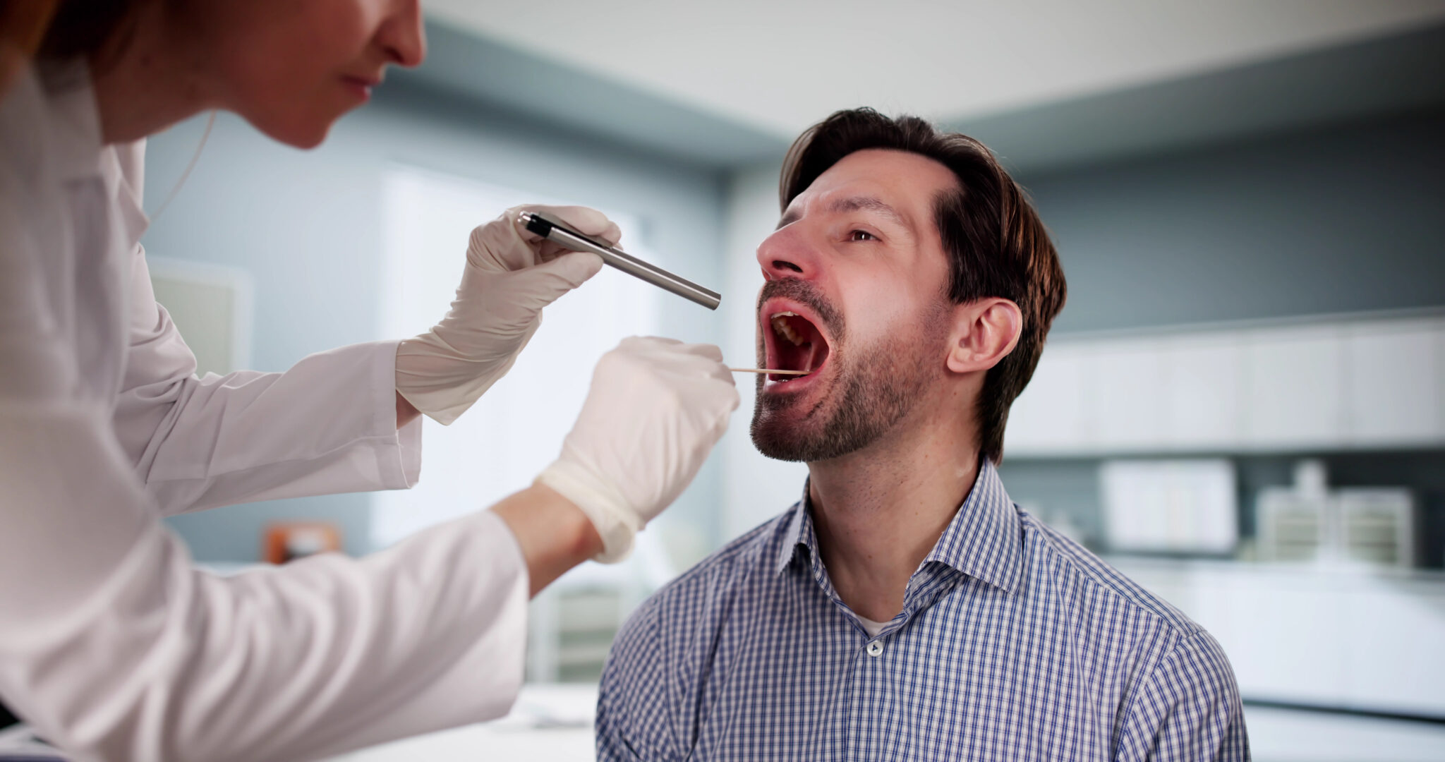 Man with a sore throat getting examined by an ENT.