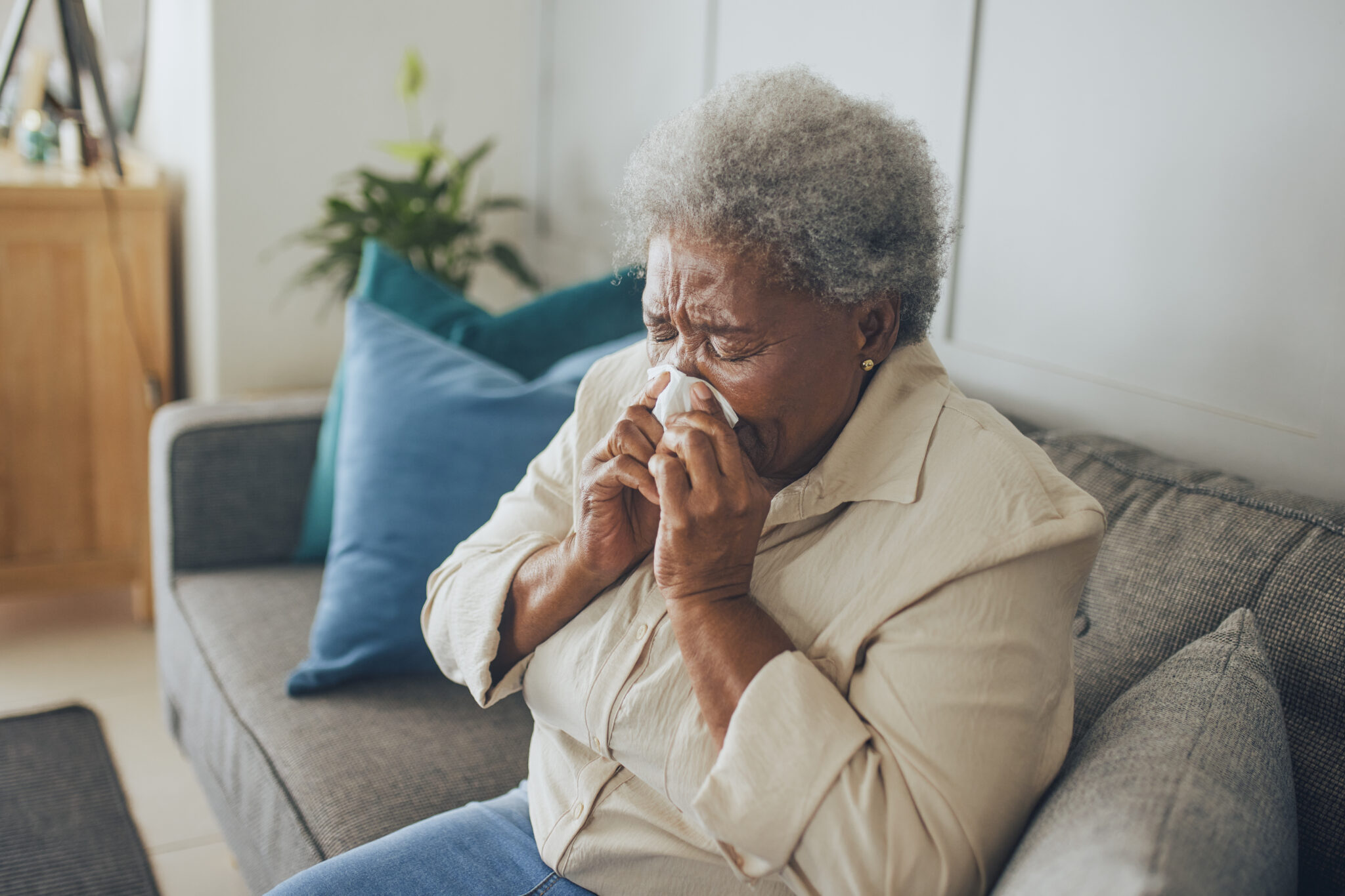 A woman blows her nose.